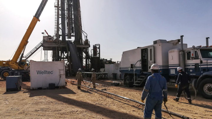 Field crew prepares for horizontal open hole logging using a Well Tractor at a desert drilling rig site.